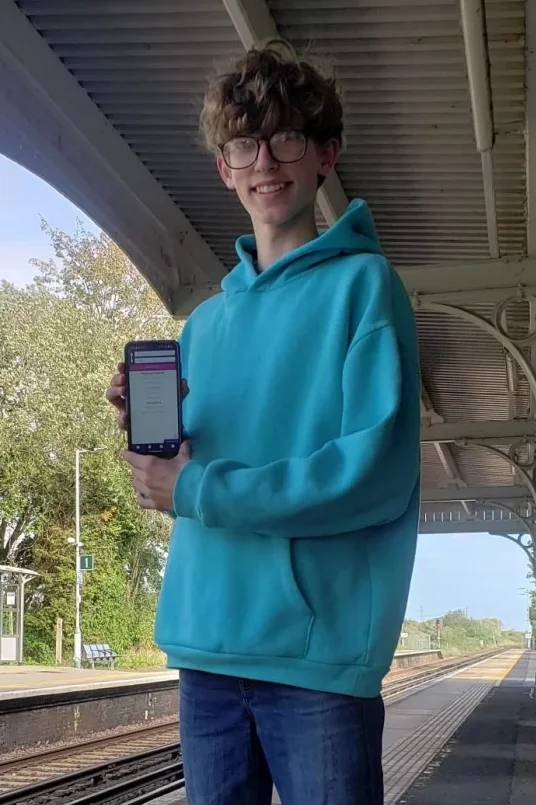 A photo of me holding a phone display my Android app